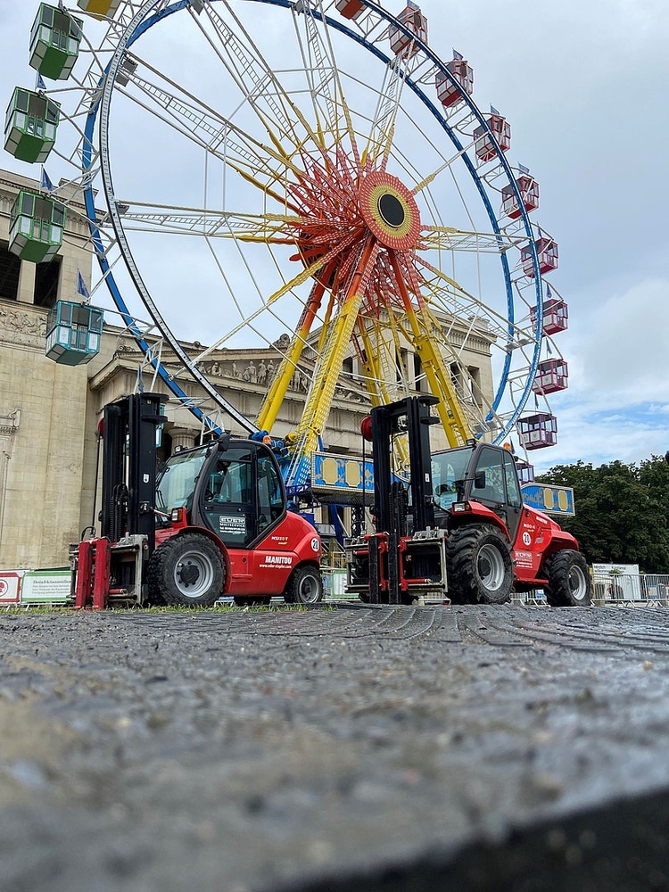 zwei Rote Manitour Stapler vor dem Riesenrad auf dem Messe Gelände