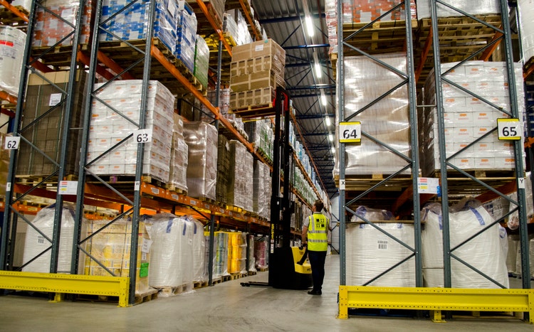 gelber Hyster S1.0 Hochhubwagen im Einsatz zwischen Hochregalen