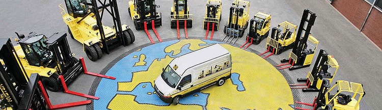 Stapler Sortiment von Hyster steht in einem Kreis um einen Hyster Van