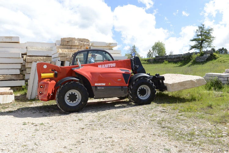 Roter Manitou Teleskopstapler befördert Steinplatten im Freien