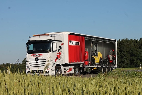 Weiß-roter EDER-Lkw mit Mercedes-Zugmaschine und Anhänger fährt im Freien