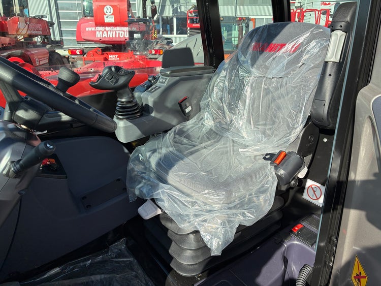 nnenraum des Manitou MHT 790 mit Fahrersitz, Joystick und Bedienelementen.