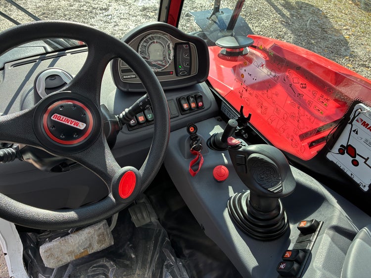 Armaturenbrett des Manitou MT 420 H ST5 mit Lenkrad, Anzeigen und Bedientasten.