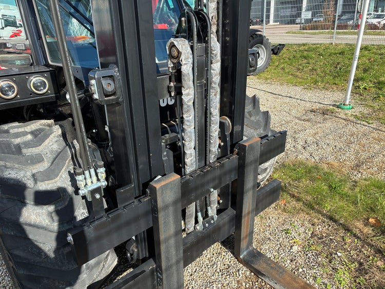 Detailansicht der Gabelzinken und Hydraulik des Manitou Geländestaplers M50-4.
