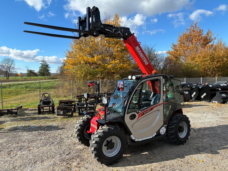 Manitou MT 420 H ST5 Kompakt-Teleskoplader mit angehobenen Gabeln auf dem Hof