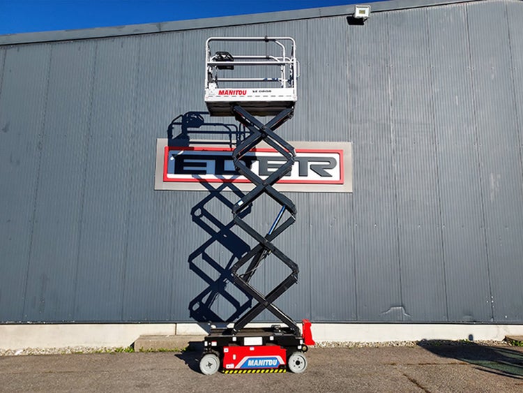 Voll ausgefahrene Manitou SE 0808 Scherenarbeitsbühne vor einer grauen Hallenwand mit grossem EDER-Logo.