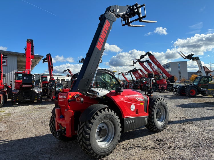 Heckansicht des Manitou MLT 630-115 D vor der EDER Stapler Werkstatt mit mehreren Teleskopladern.