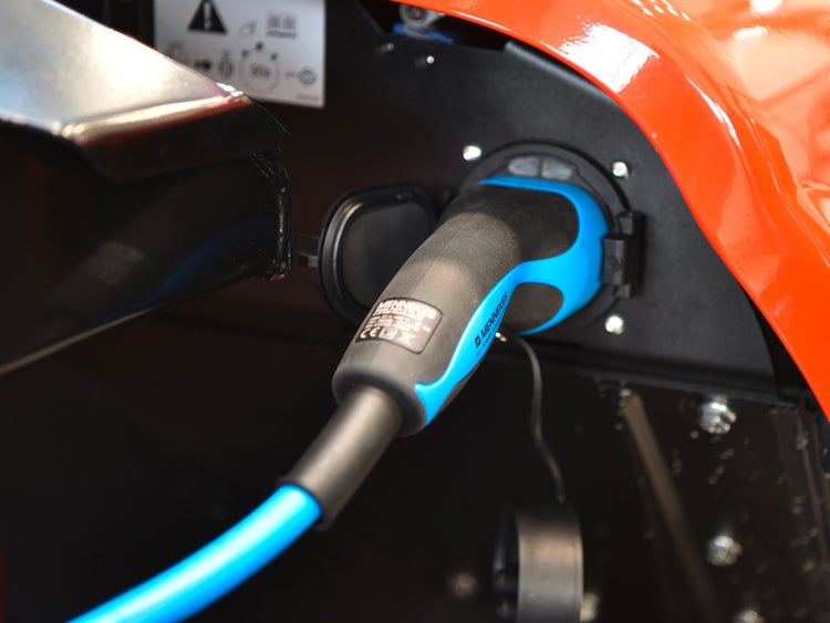 Detailaufnahme eines blauen Ladekabels, das an eine Ladevorrichtung eines Manitou Elektrofahrzeugs angeschlossen ist.