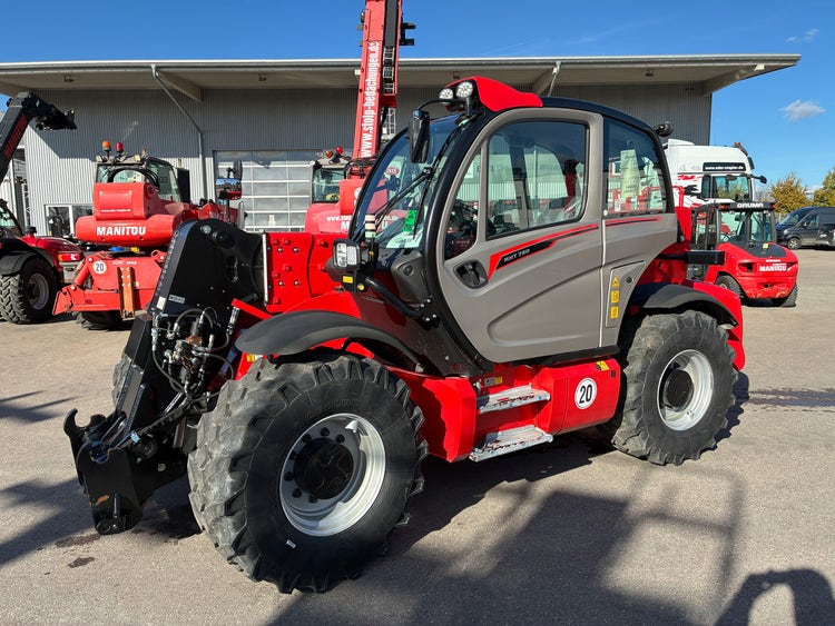 Manitou Teleskoplader MHT 790 von der Seite mit geschlossener Fahrerkabine auf dem Hof.