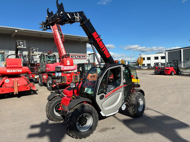 Manitou MLT 625 H 75K Teleskoplader mit angehobenen Gabeln auf dem Hof bei EDER.