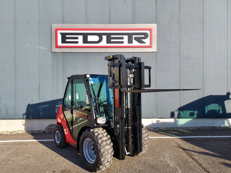 Manitou MSI 30 Gabelstapler schräg von vorn mit hochgefahrener Gabel vor einer grauen Wand mit EDER-Logo.