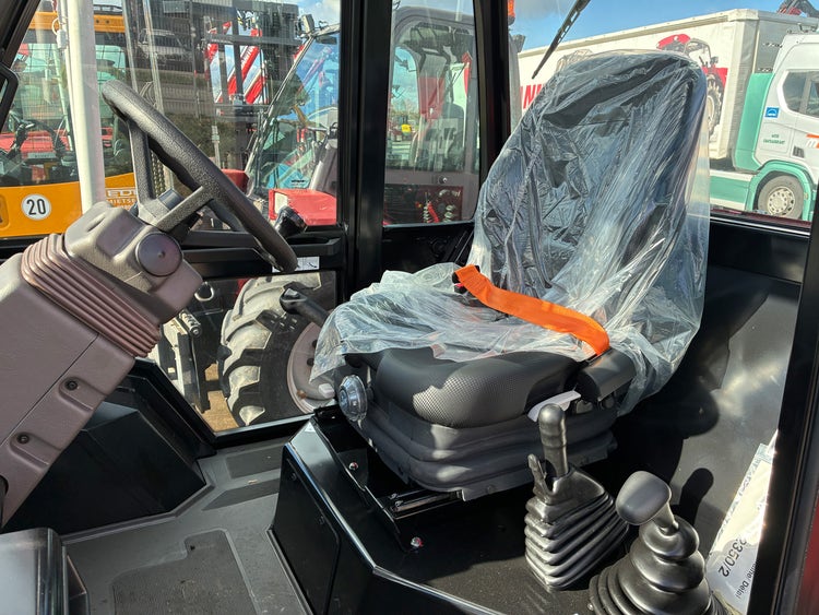 Innenraum des Manitou Geländestaplers M50-4 mit Fahrersitz, Lenkrad und Bedienelementen.