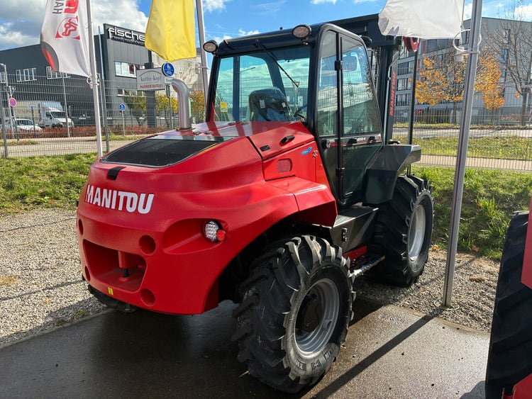 Roter Manitou Geländestapler M50-4 auf dem Firmengelände bei sonnigem Wetter