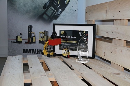 Hyster Stapler Urkunde steht auf einer Holzpalette mit mini Hyster Stapler davor.