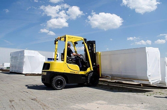 Gelber Hyster Gabelstapler transportiert verpackte Warenpaletten im Freien