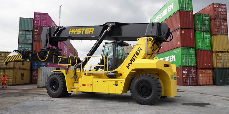 Hyster Reachstacker beim Containerumschlag vor gestapelten Frachtcontainern.