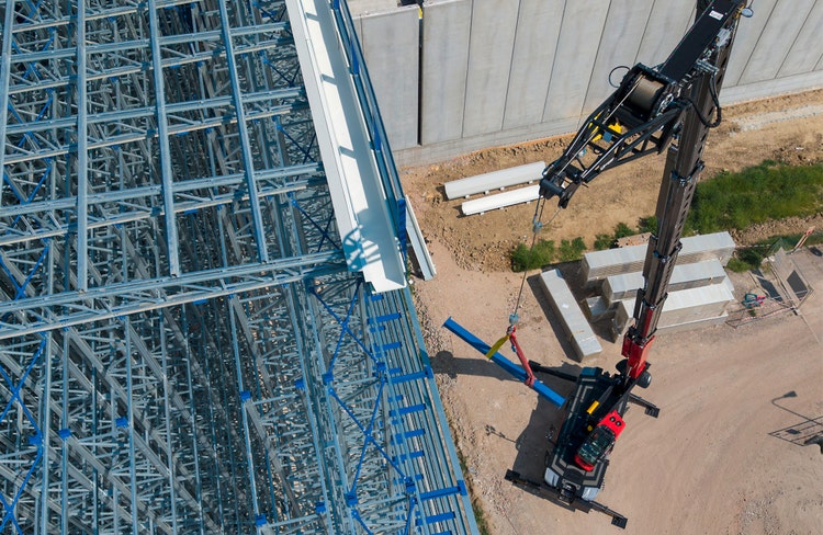 Manitou MRT 4080 drehbarer Teleskoplader im Baustelleneinsatz mit ausgefahrenem Teleskoparm der Material transportiert.