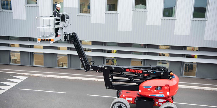 eine rot Gelenkteleskopbühne von Manitou im einsatz