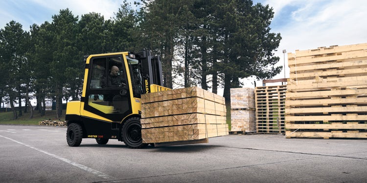 Gelber Hyster Gabelstapler der Holz transportiert